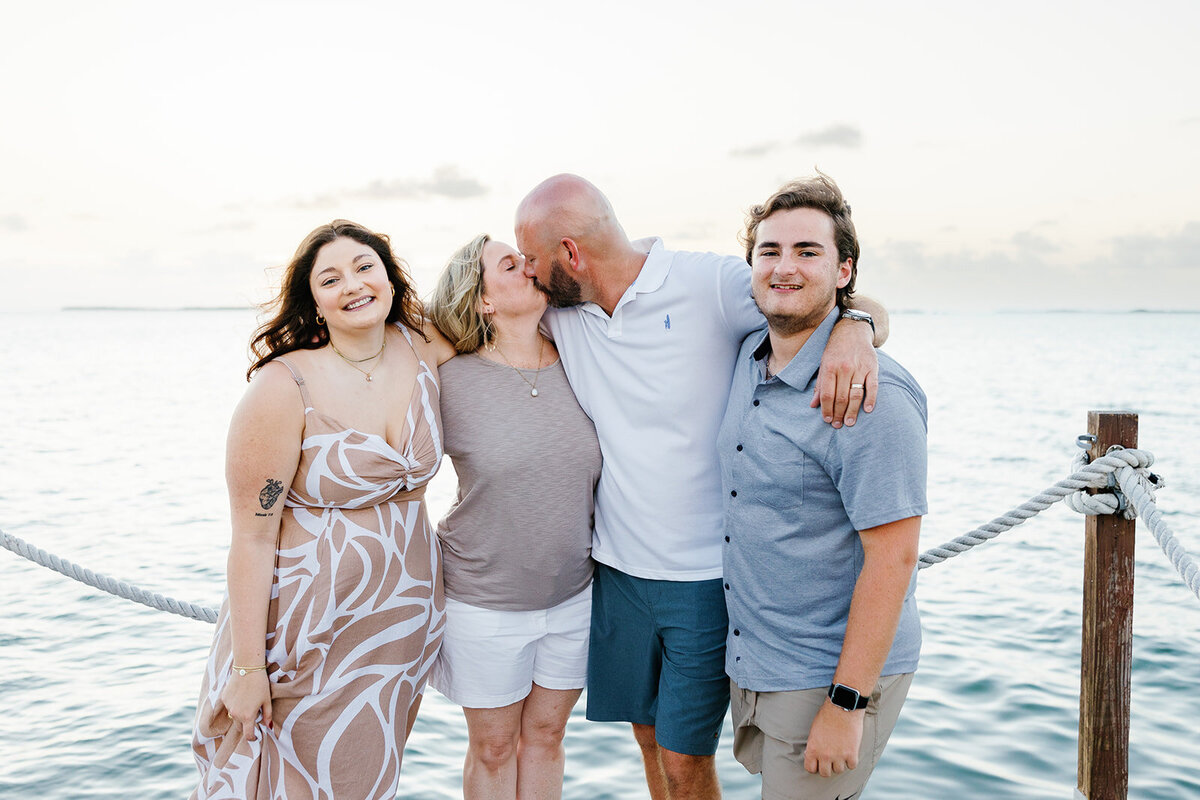 A close-knit family shares a warm hug with an ocean backdrop during a Florida Keys family session by Claudia Amalia.