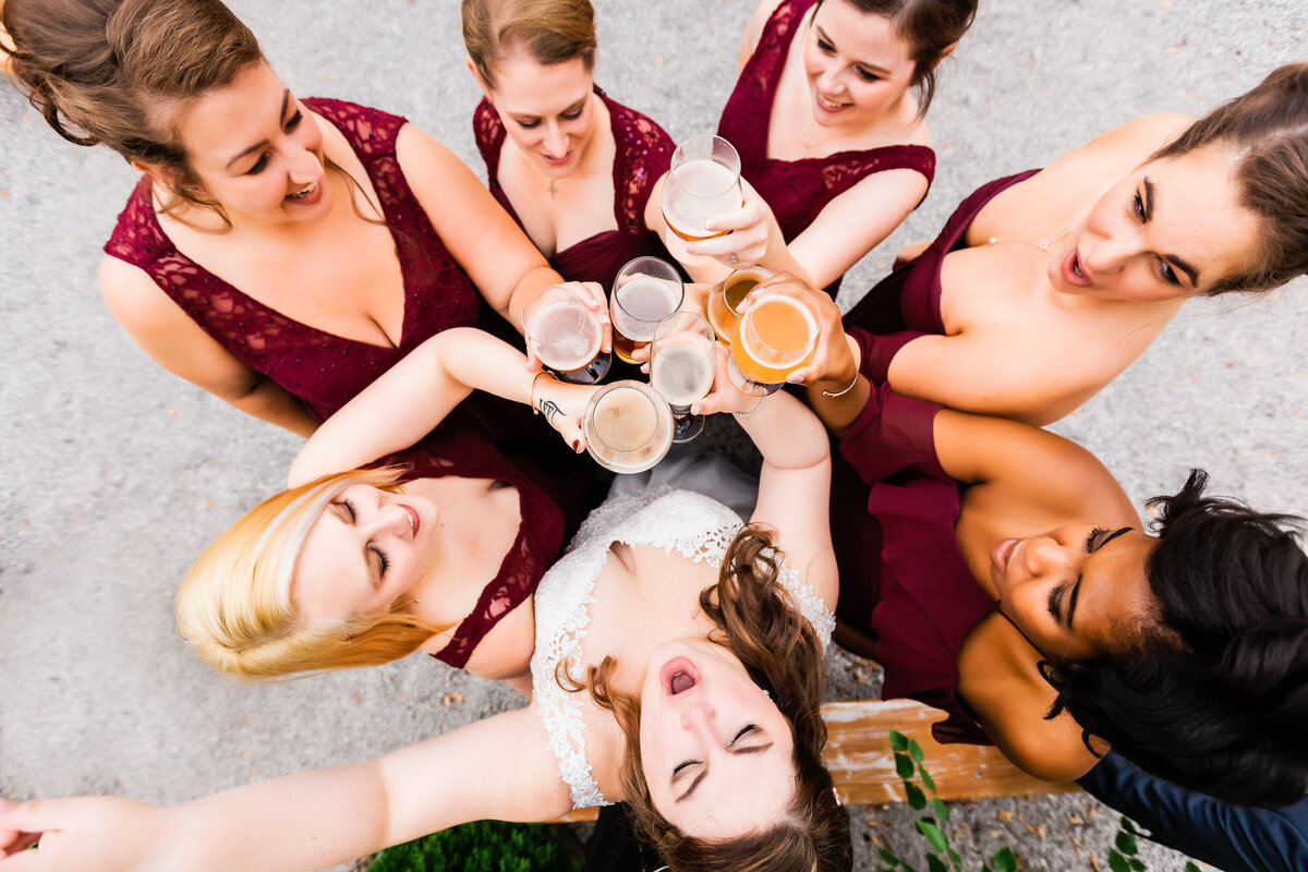 Bride and bridesmaids toasting their beers and cheering