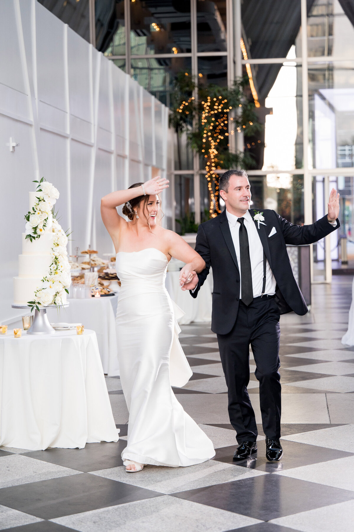 married couple happily coming into their wedding reception at the wintergarden ppg place