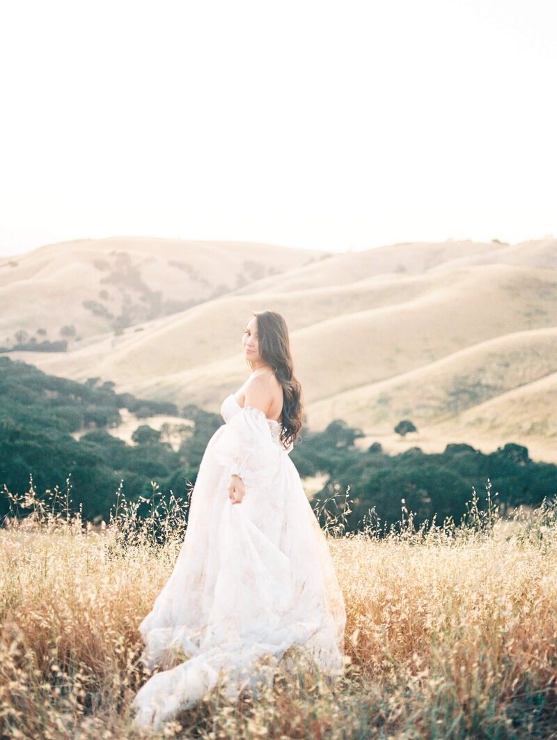 Pregnant woman framing her belly in a tulle dress taken by San Francisco Maternity Photographer Laurel Smith.