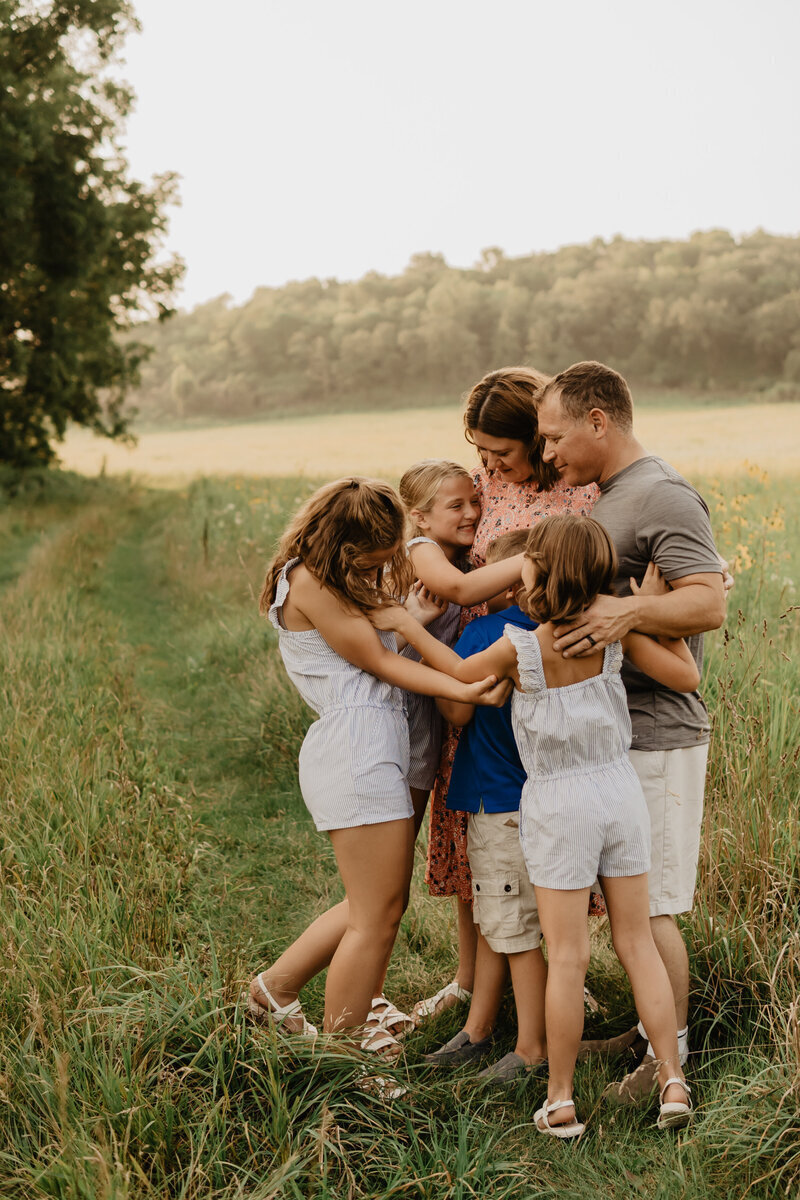 sunset-family-hug-session-wildflower-field-Brushy-Creek-State-Recreation-Area-Lehigh-iowa-storyteller-collective-photo-co