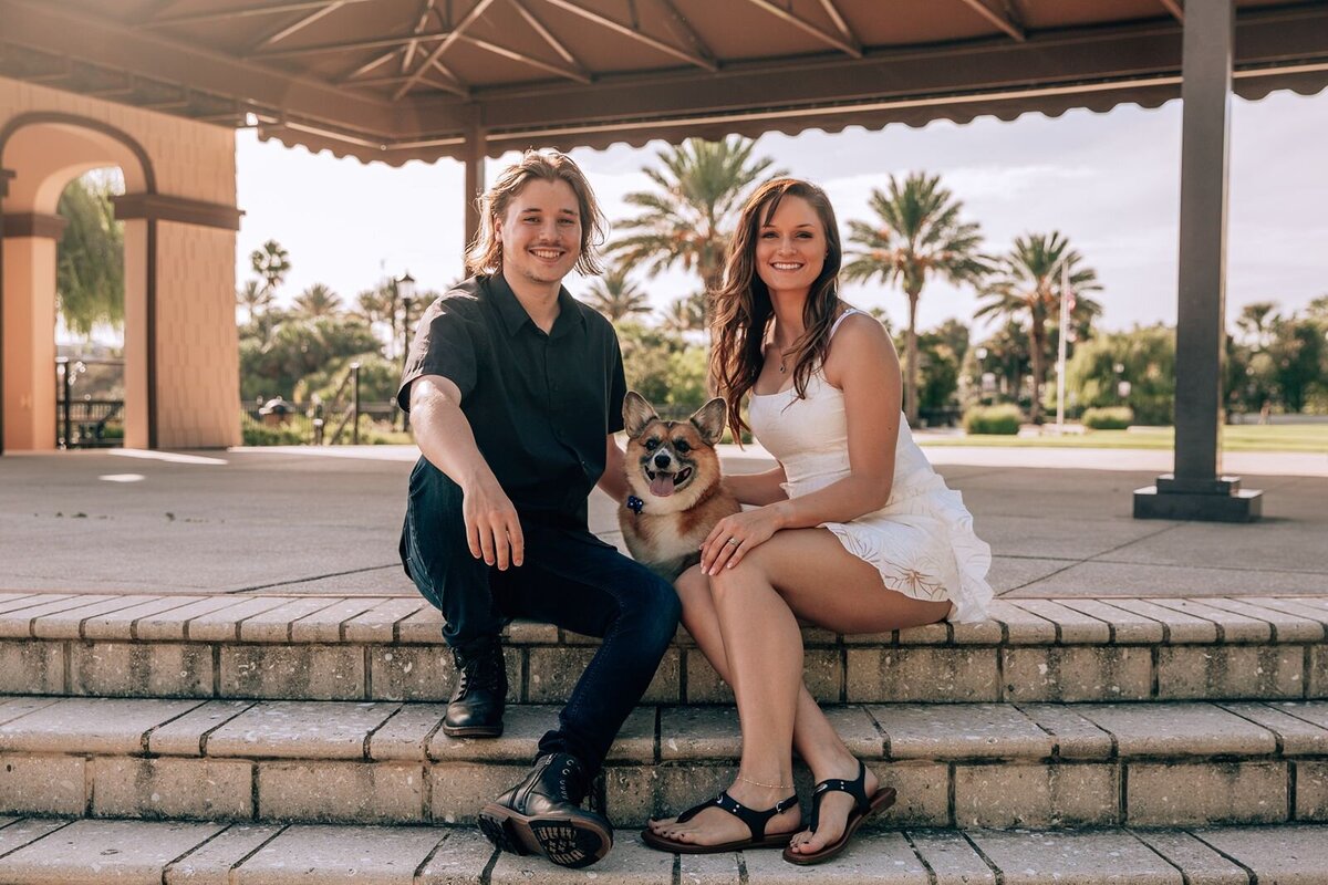 engaged couple takes photos with their corgi