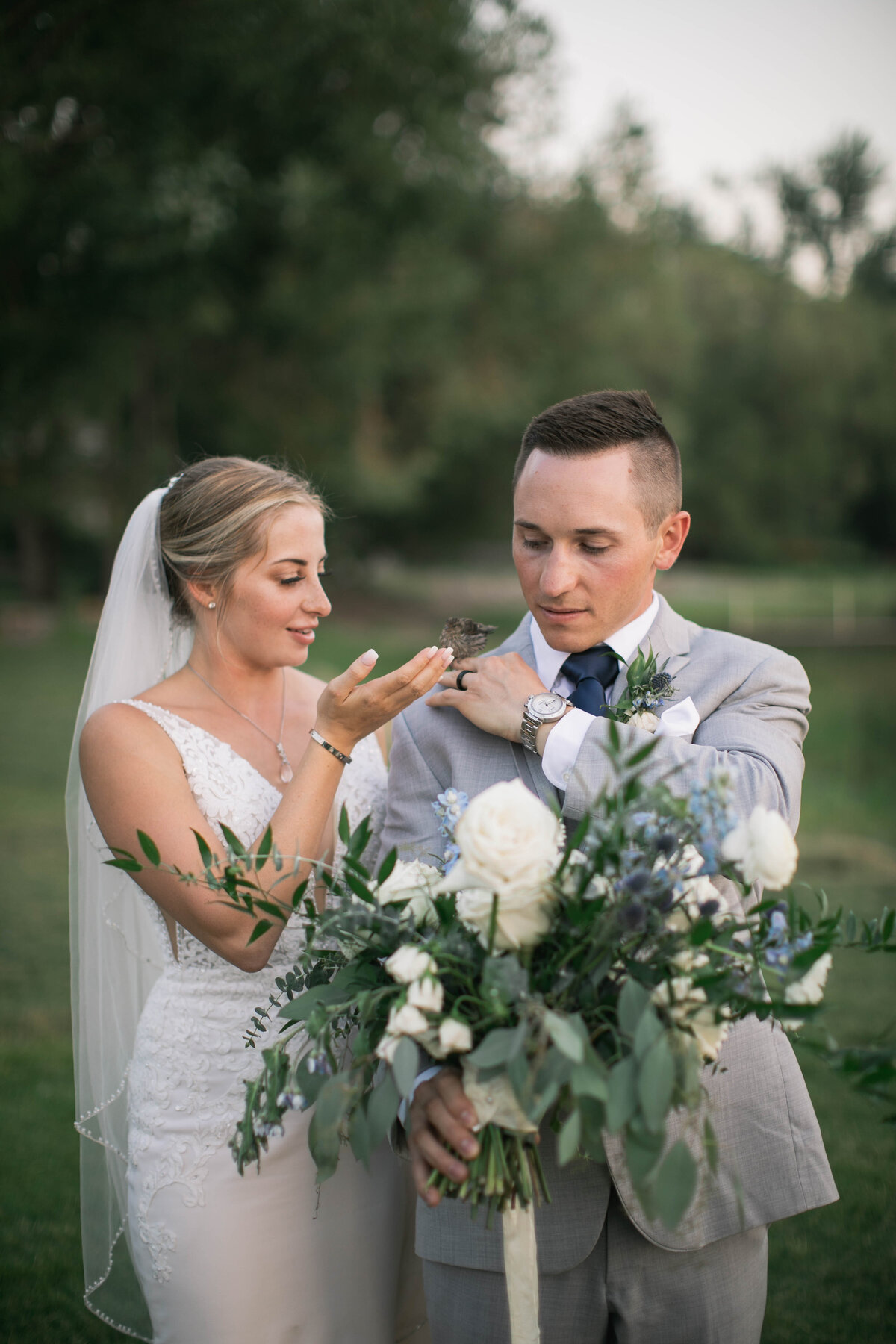 bride and groom holding bird