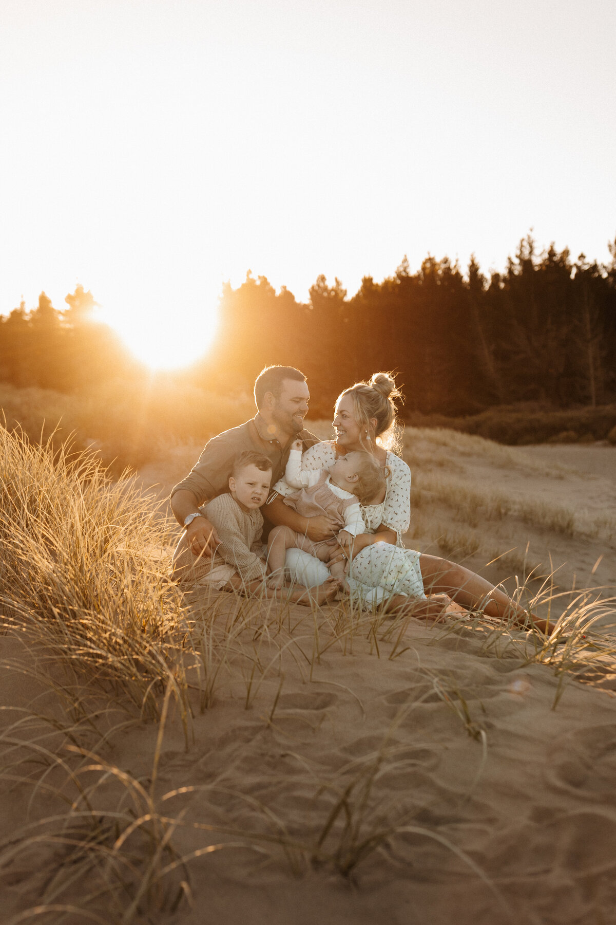 A mother, father and their two children being photographed candidly by christchurch family photographer lucy jane