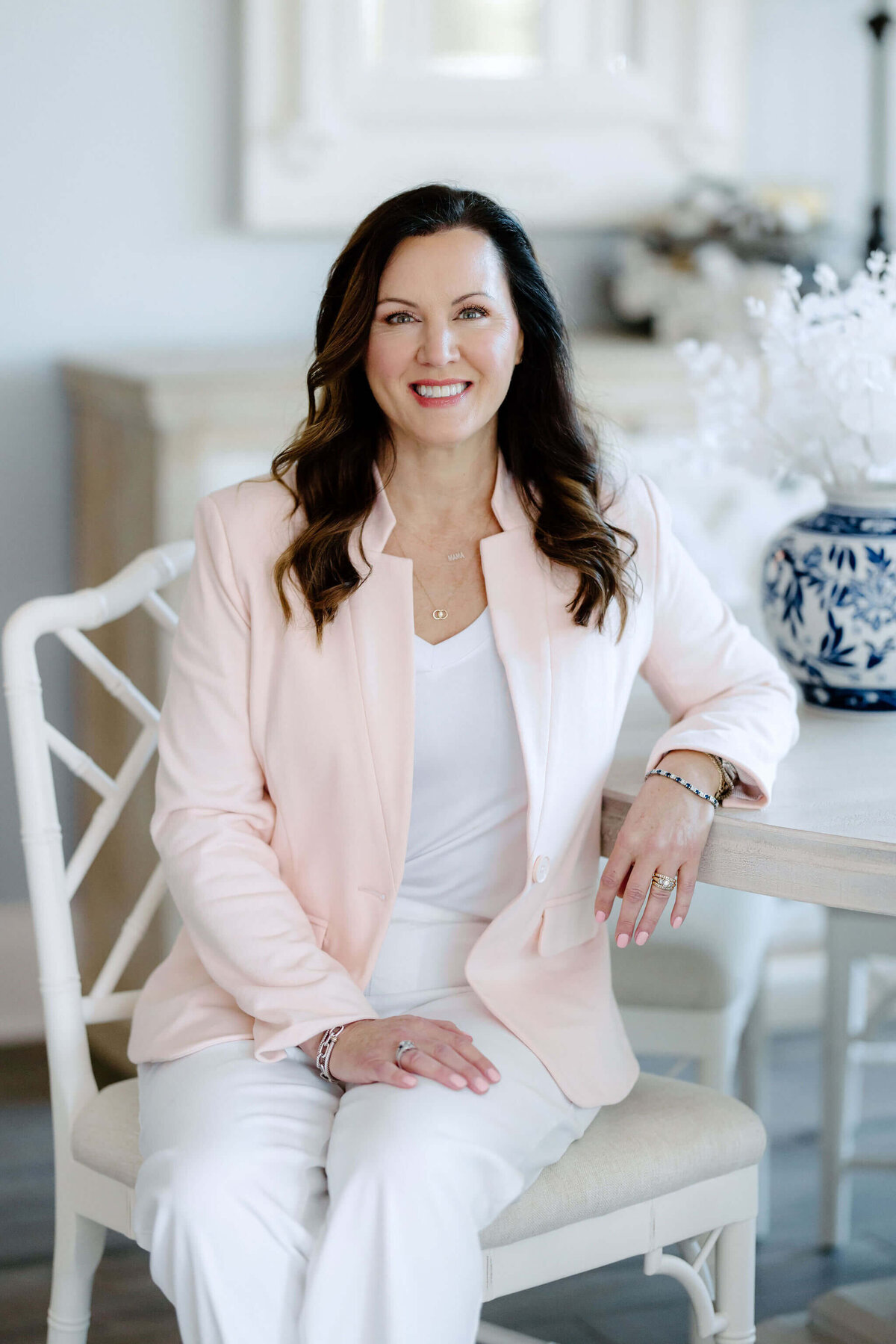 Candid headshot of East Texas Realtor sitting at table wearing light pink sports coat