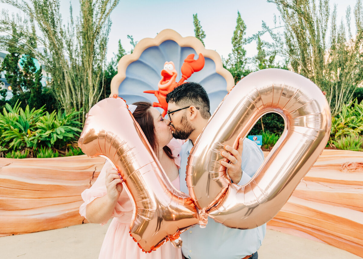 couple holding inflated number 10 and kissing