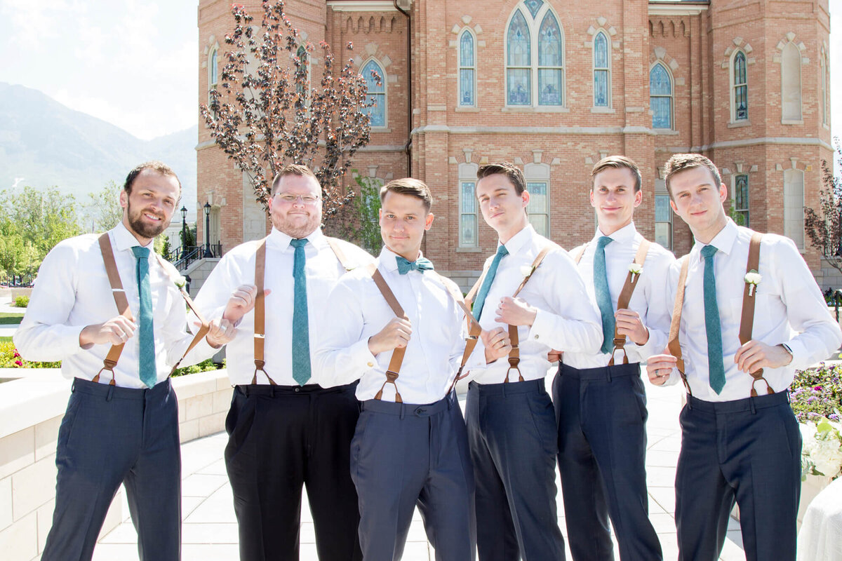 six groomsmen pulling on their suspenders