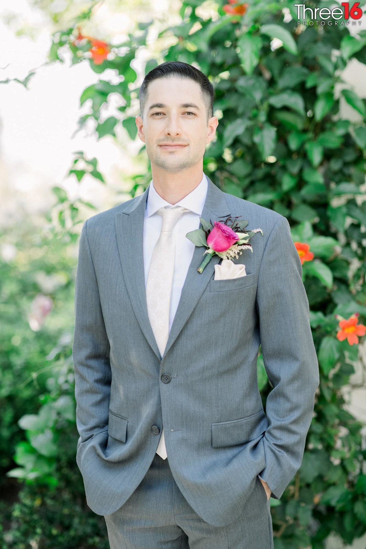 Groom poses with his hands in his pockets