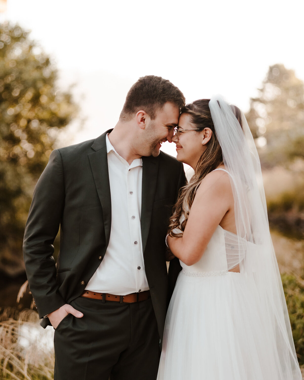 a bride and groom touching foreheads