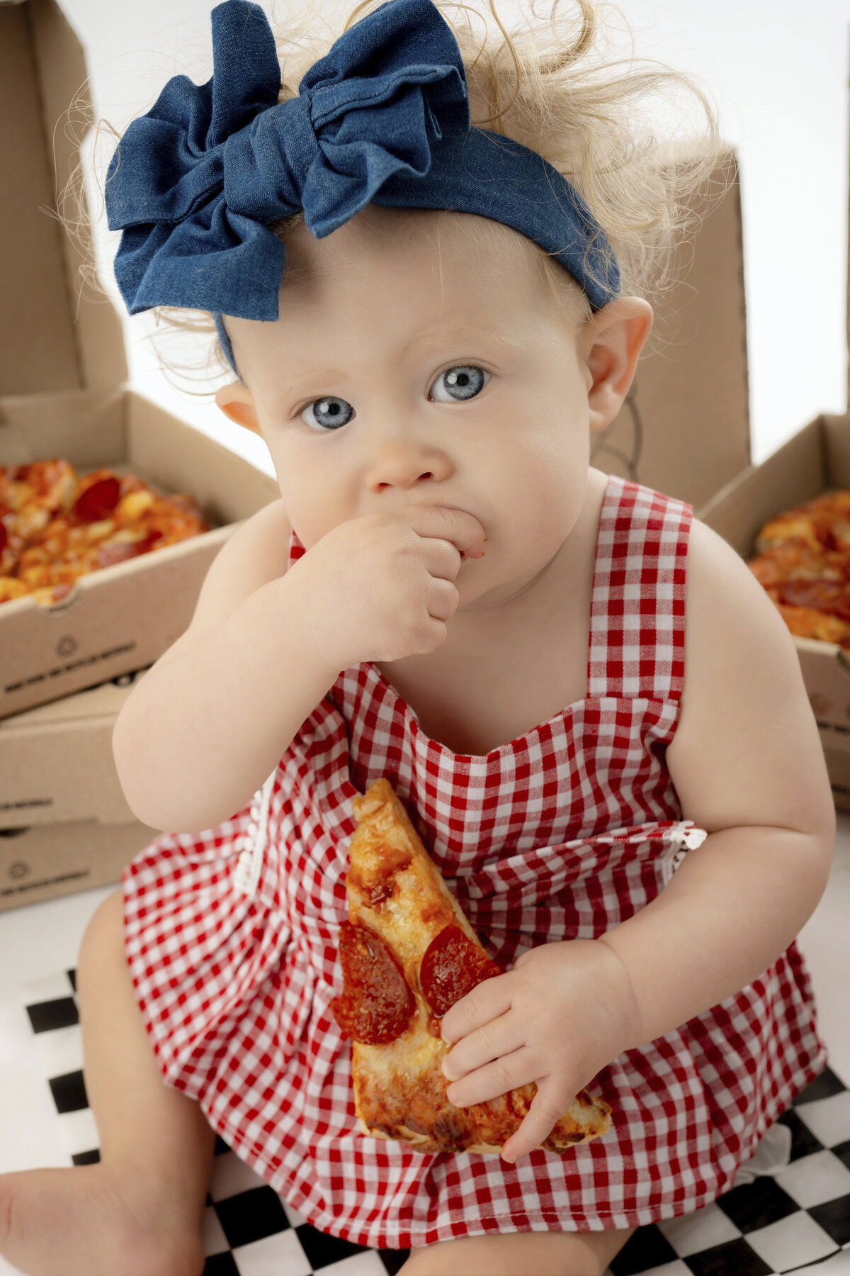 Baby girl chews on her hand in her Iowa Milestone Photos
