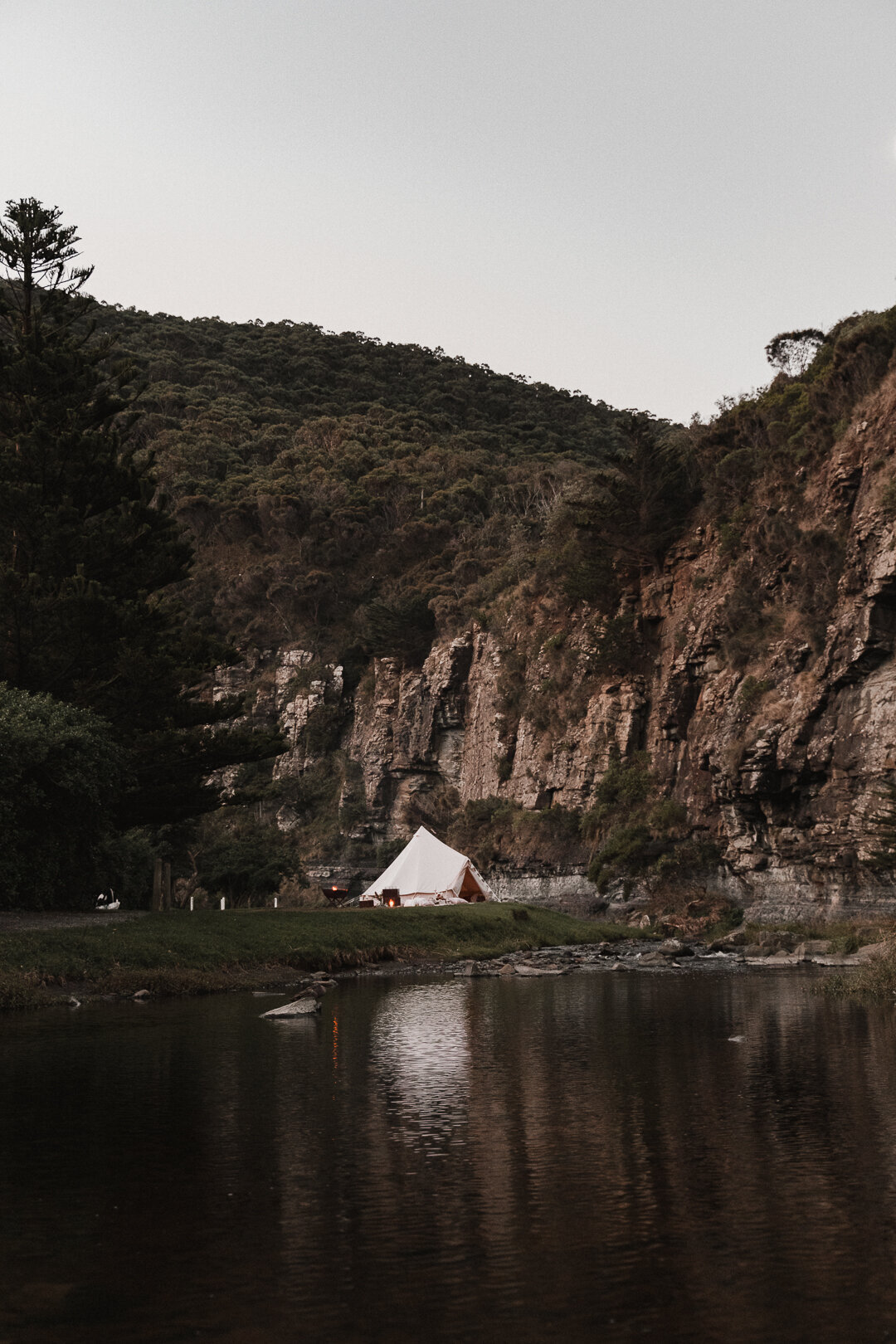 Elopement set up with campfire and glamping tent by river in the mountains