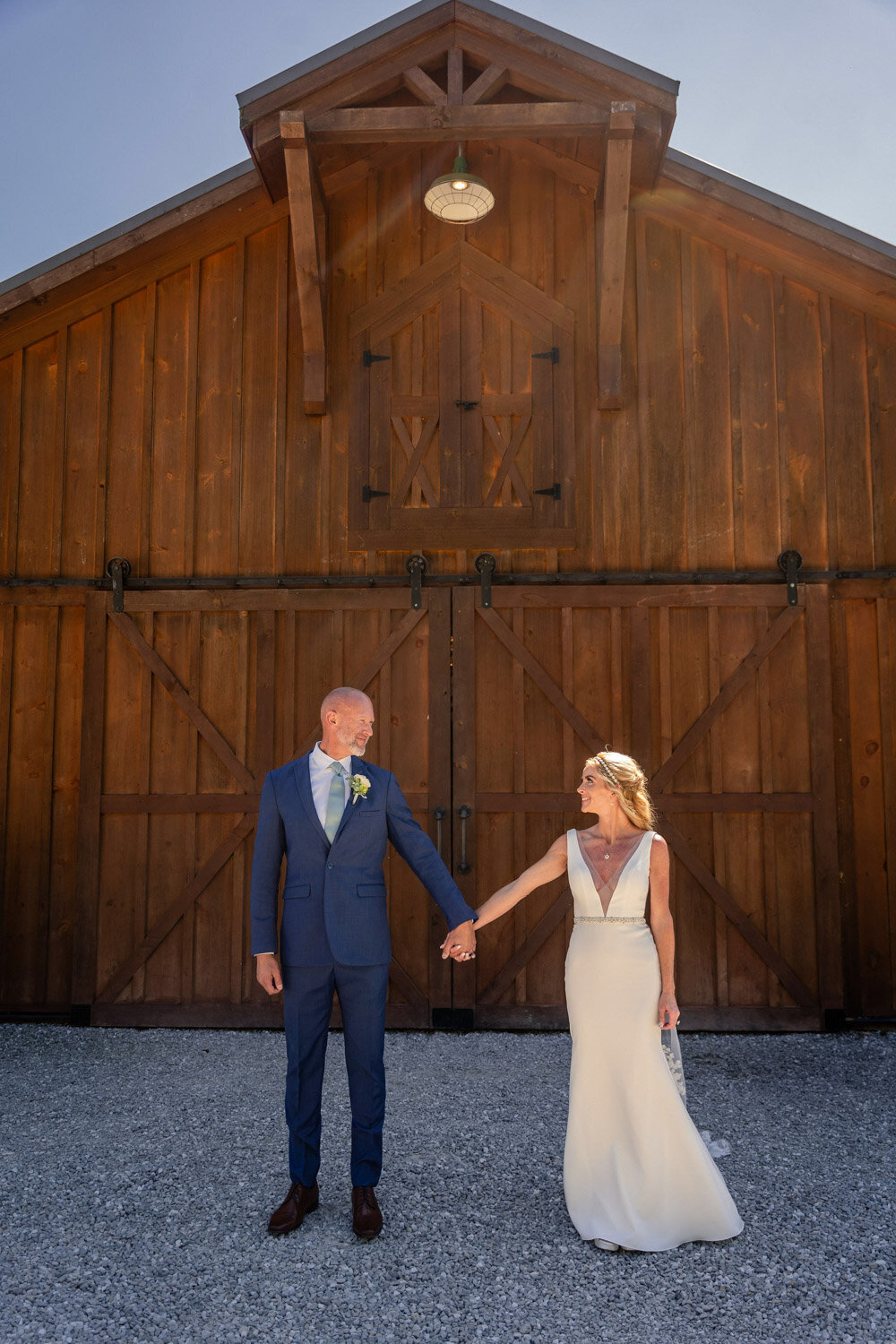 Bride and groom hold hands at the back of the wedding venue