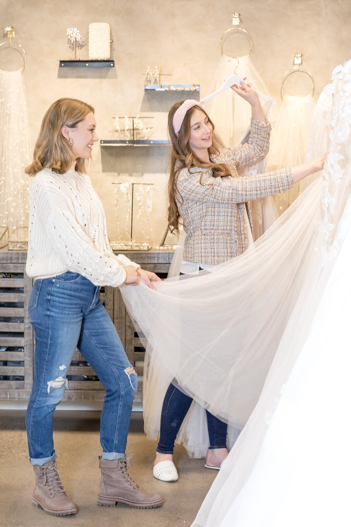 women adjusting a wedding dress that is on display