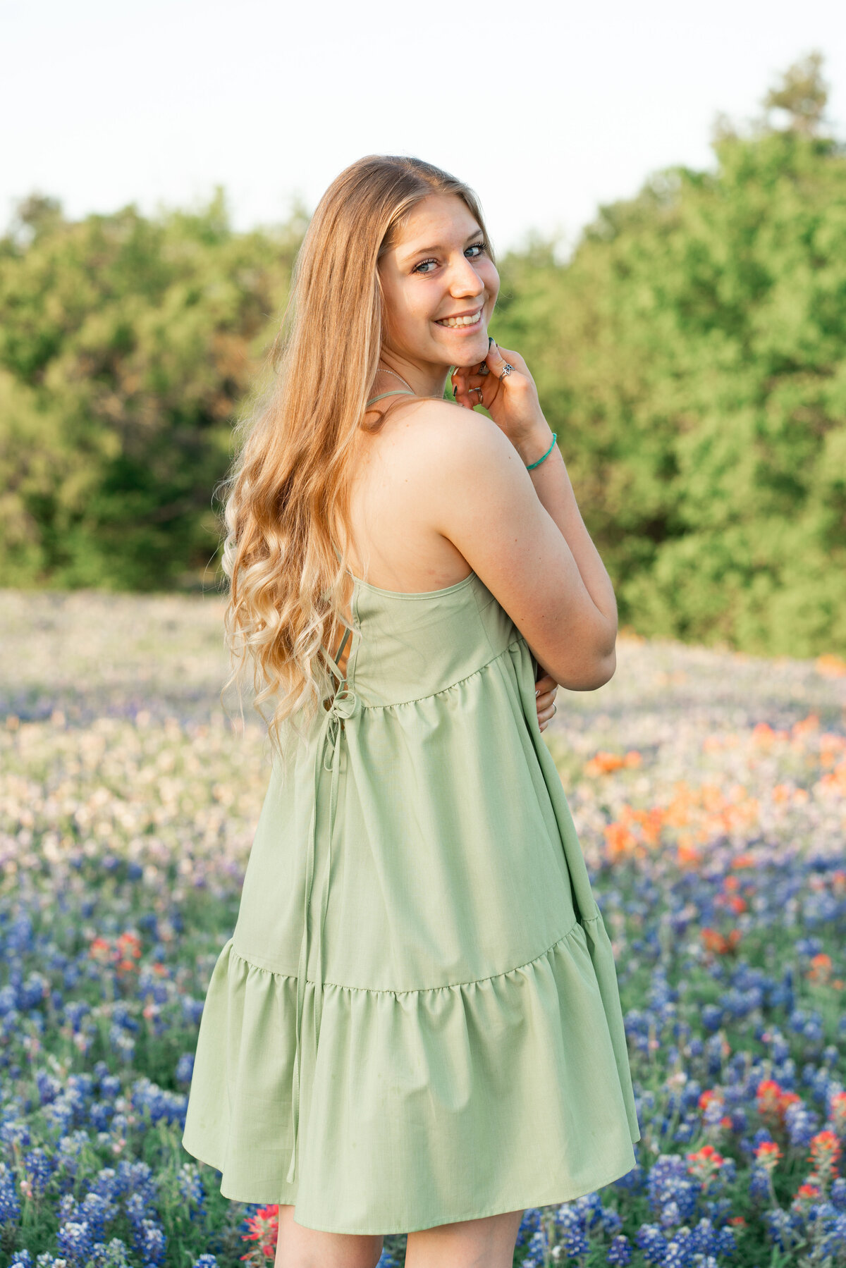 High school girl with dress in the wildflowers for senior photos. In Austin Texas.