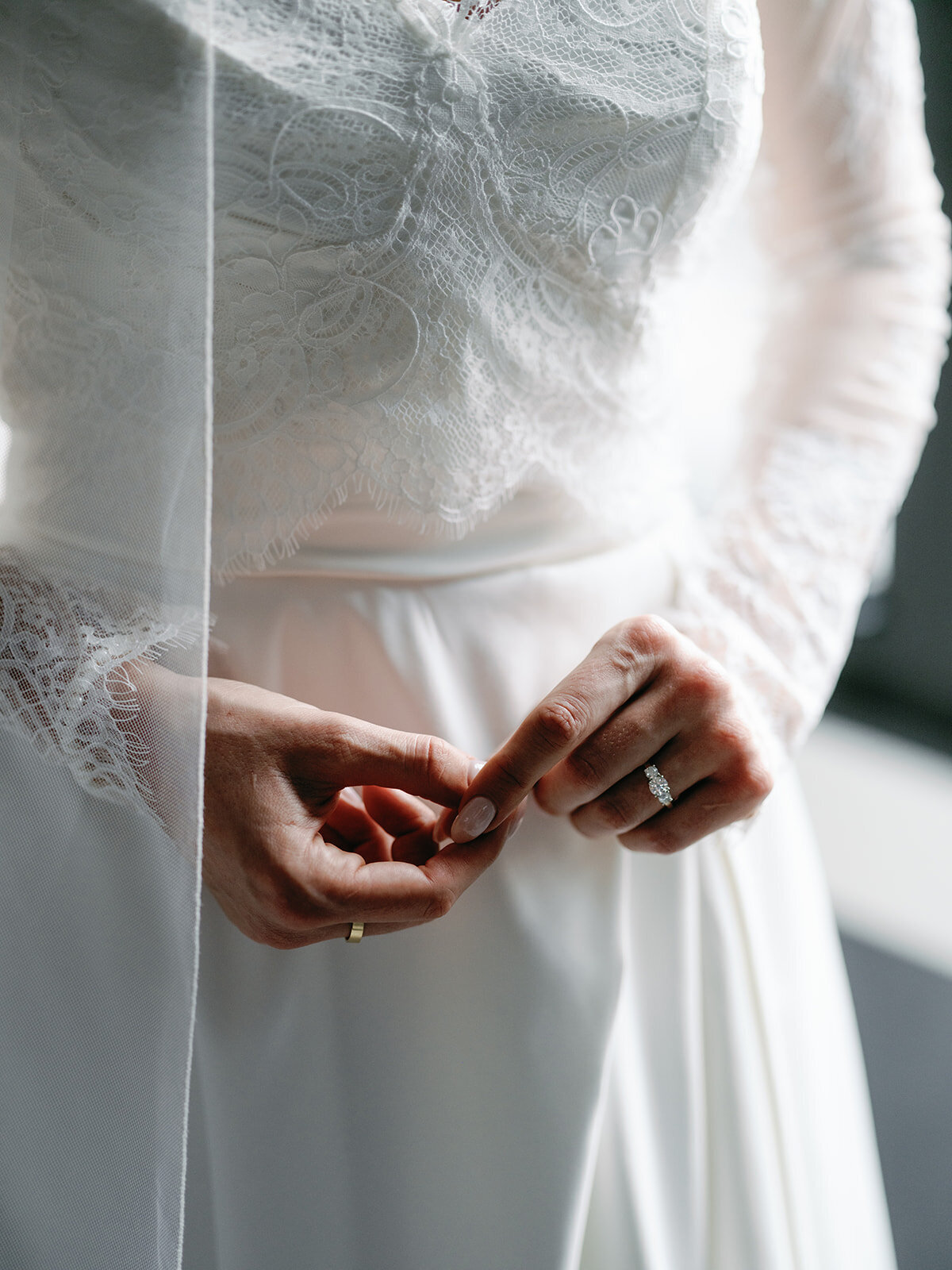 Brides hands in front of her wedding dress