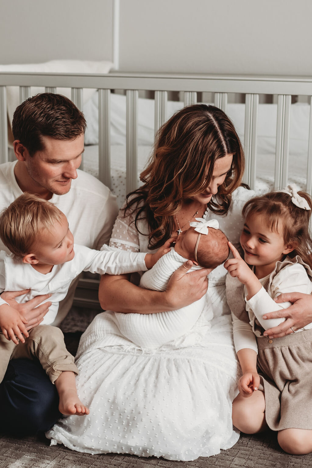 family of five sitting in newborn nursery for denver photographer