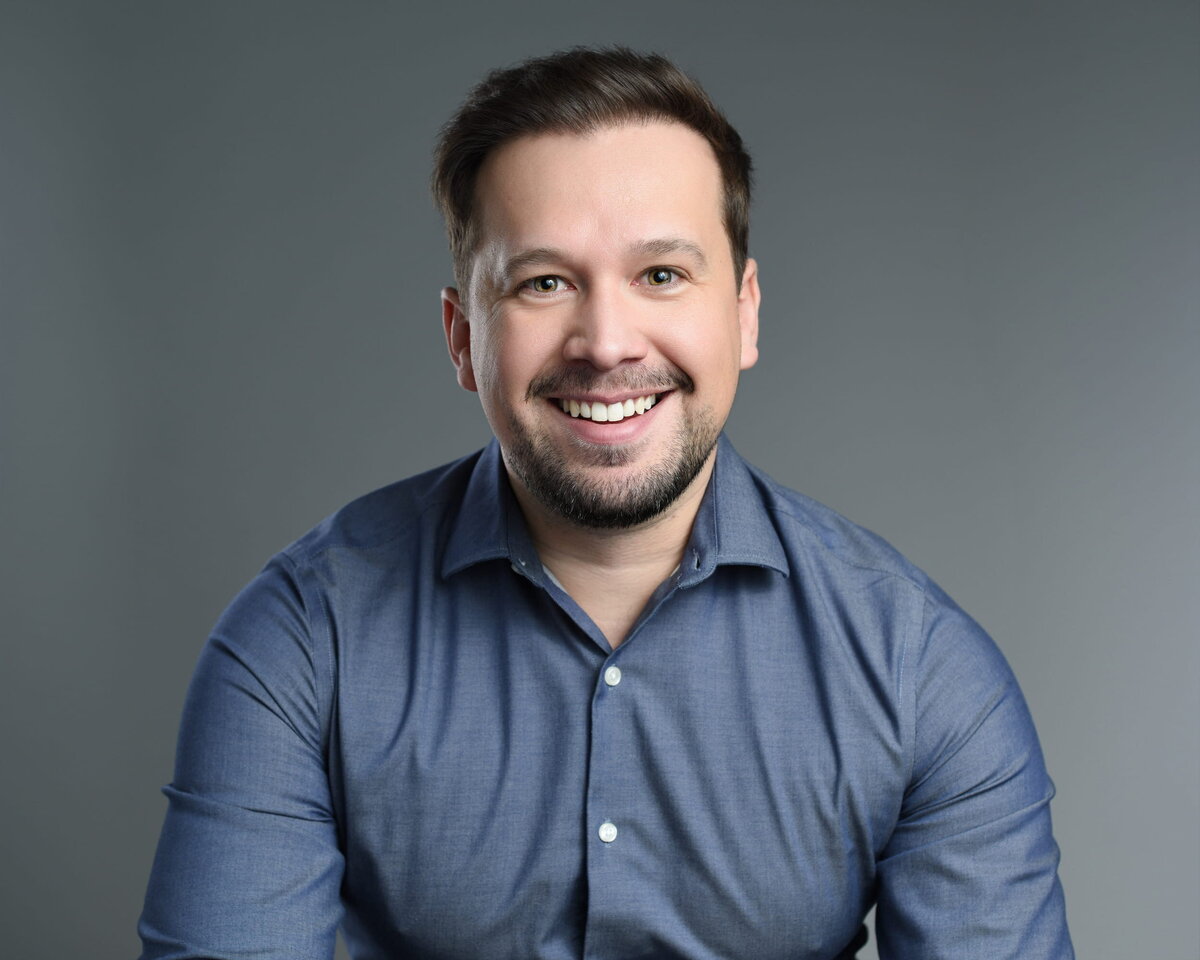 Casual professional headshot of a young man smiling taken by a Toronto headshot photographer.