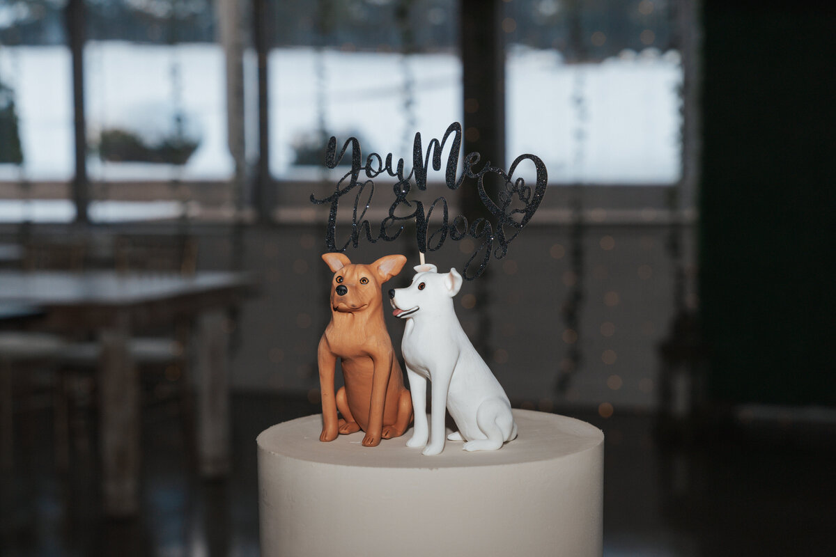 Dog themed cake topper sits in a white wedding cake 