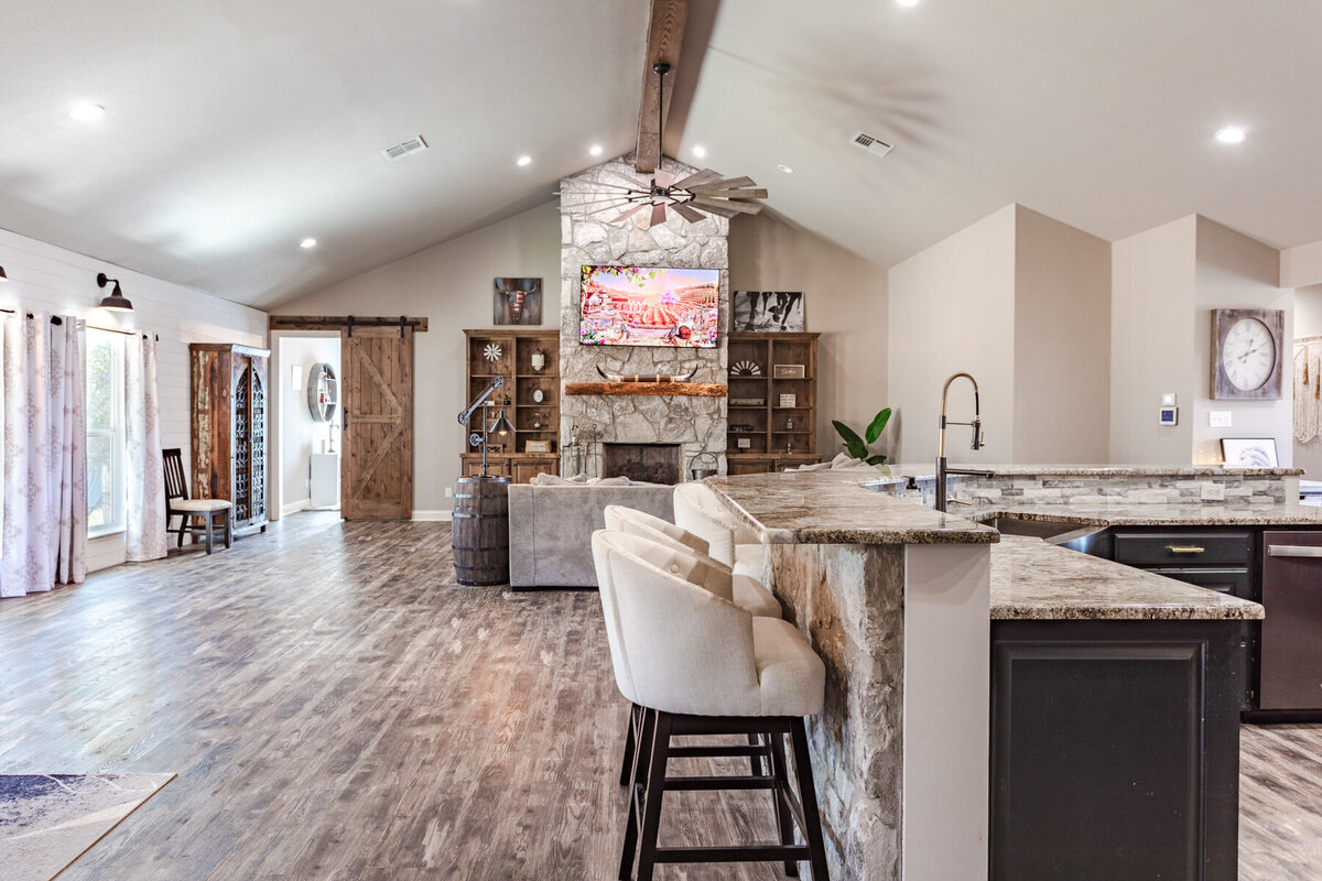Open concept living room and fully stocked kitchen in this five-bedroom, 3-bathroom vacation rental house for up to 10 guests with free wifi, private parking, outdoor games and seating, and bbq grill on 2 acres of land near Waco, TX.