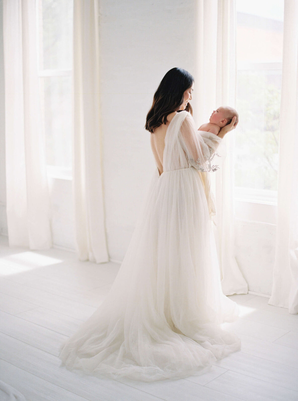 Mother cuddling with newborn at Bay Area newborn photographer session.