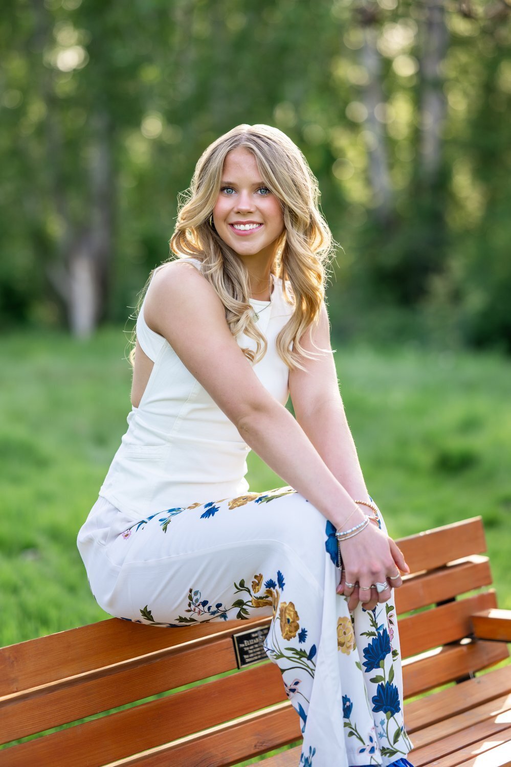 senior girl sitting on back of bench at juanita park washington