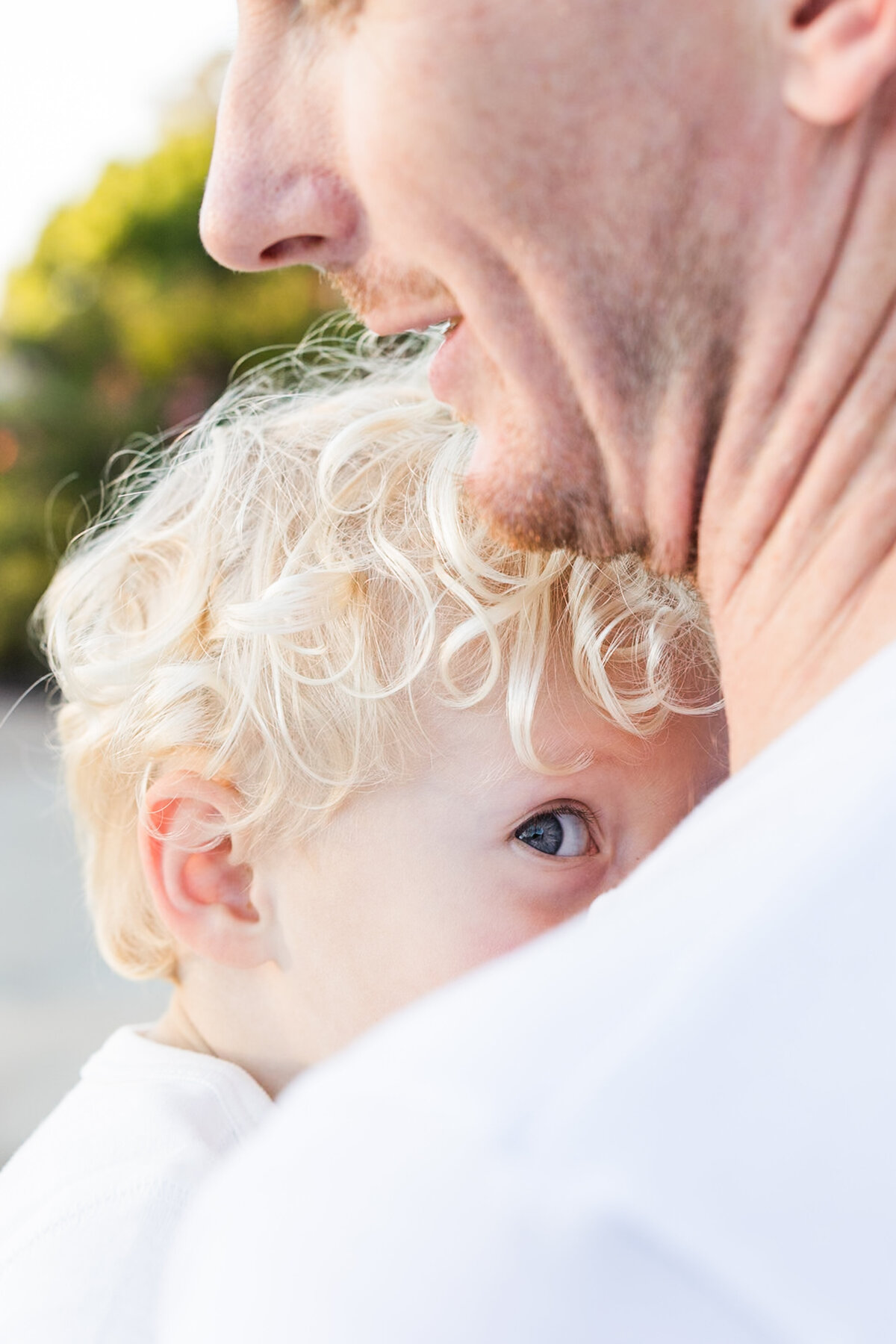 young boy looking over fathers shoulder