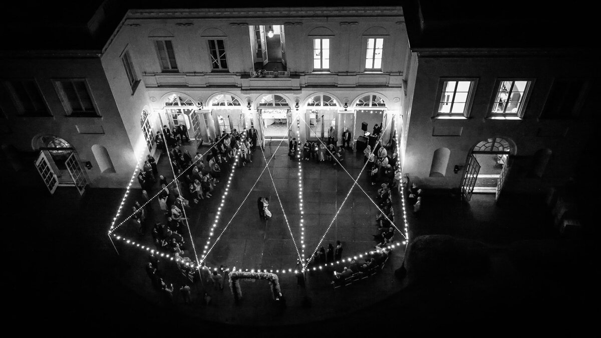 drone image of first dance at mansion under twinkle lights under patio at wadsworth mansion wedding photo by cait fletcher photography