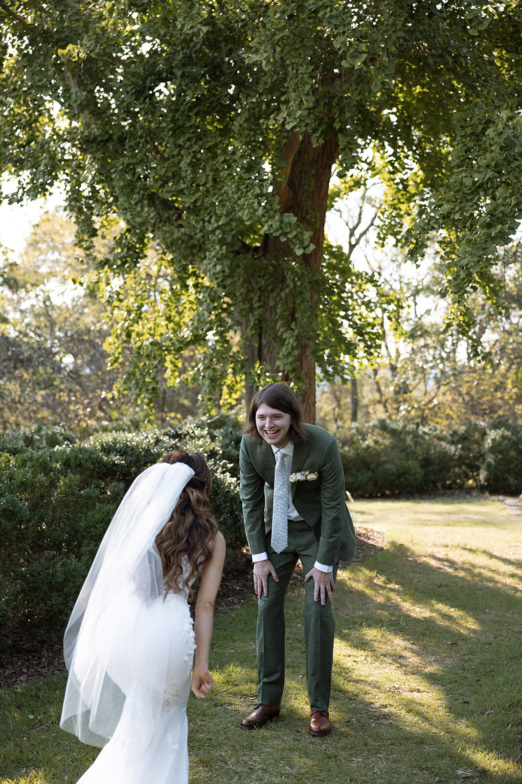 Groom sees bride for the first time and smiles in excitement and surprise. 