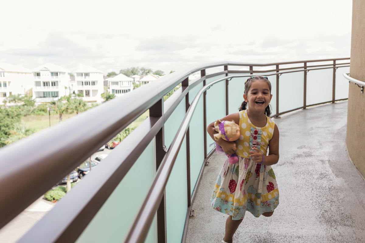 charlotte documentary photographer jamie lucido captures a day in the life of girl running down a hotel balcony at Myrtle Beach, North Carolina