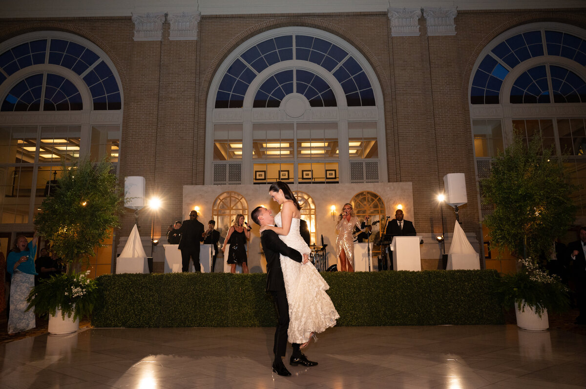 Bride and groom dancing in front of a wedding band in Dallas