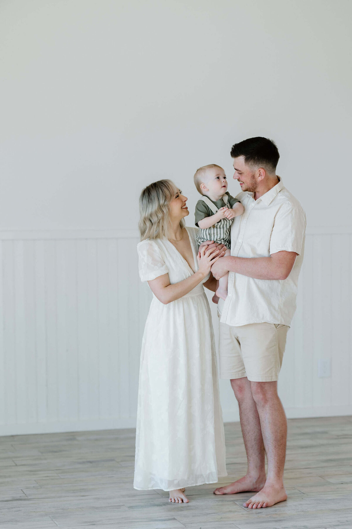 light and airy family portrait of young family holding one year old son at El Cerrito Lodge