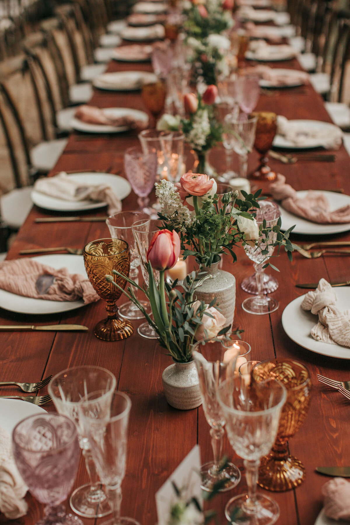 A blush and wood toned wedding tablescape with small floral arrangements