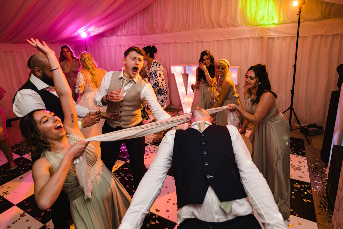 Guests doing limbo on the dancefloor marquee wedding