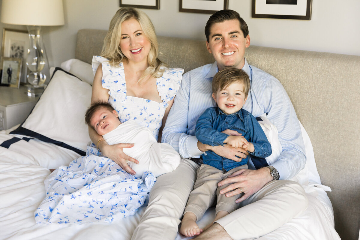 family smiling together in lifestyle session with newborn baby