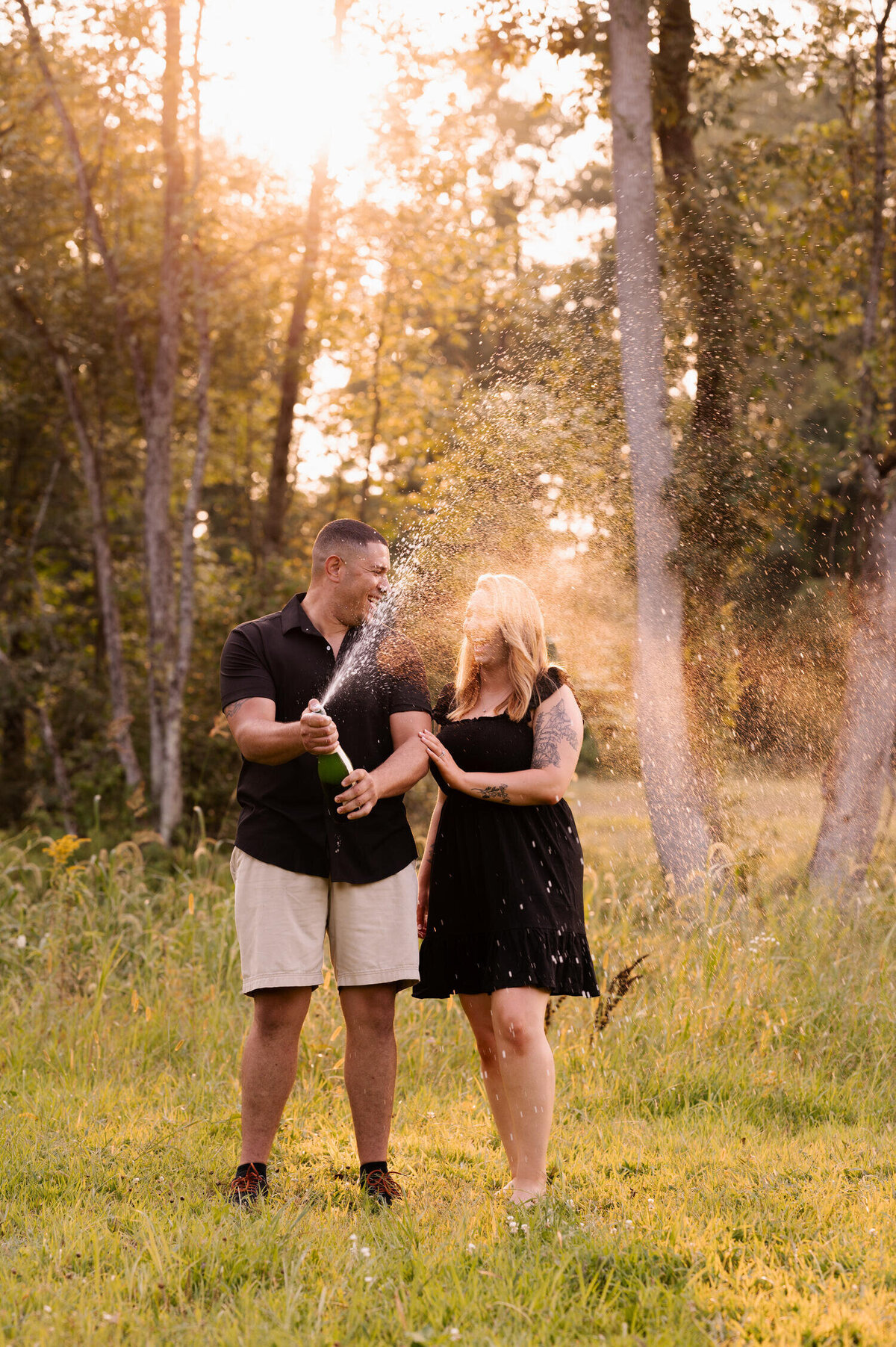 Popping champagne to celebrate their engagement photos at Hudson Crossing Park in Schuylerville, NY.