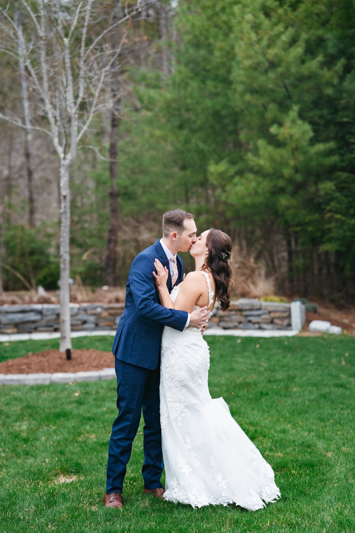 First look between bride and groom on a tree-lined path