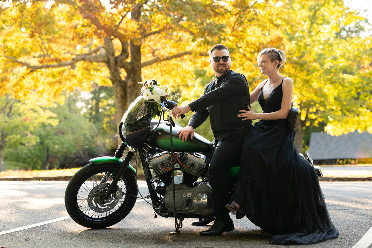 couple sits together on their motorcycle on their wedding day