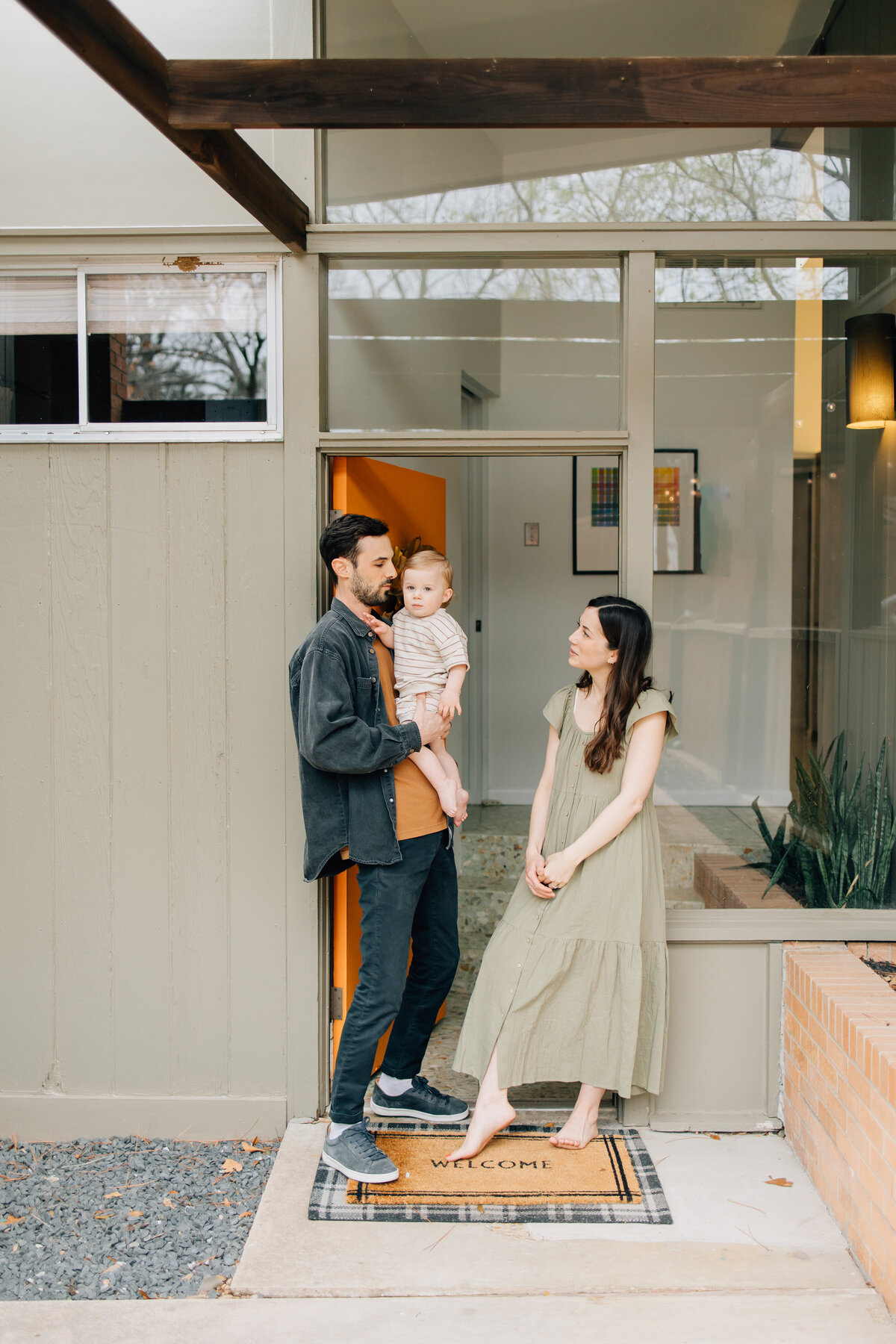 In-home session taken in Denton, TX of a family in their mid-century home . Mother, father, and one year old son.