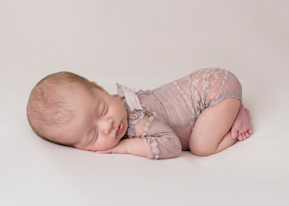 newborn-girl-in-mauve-lace-romper