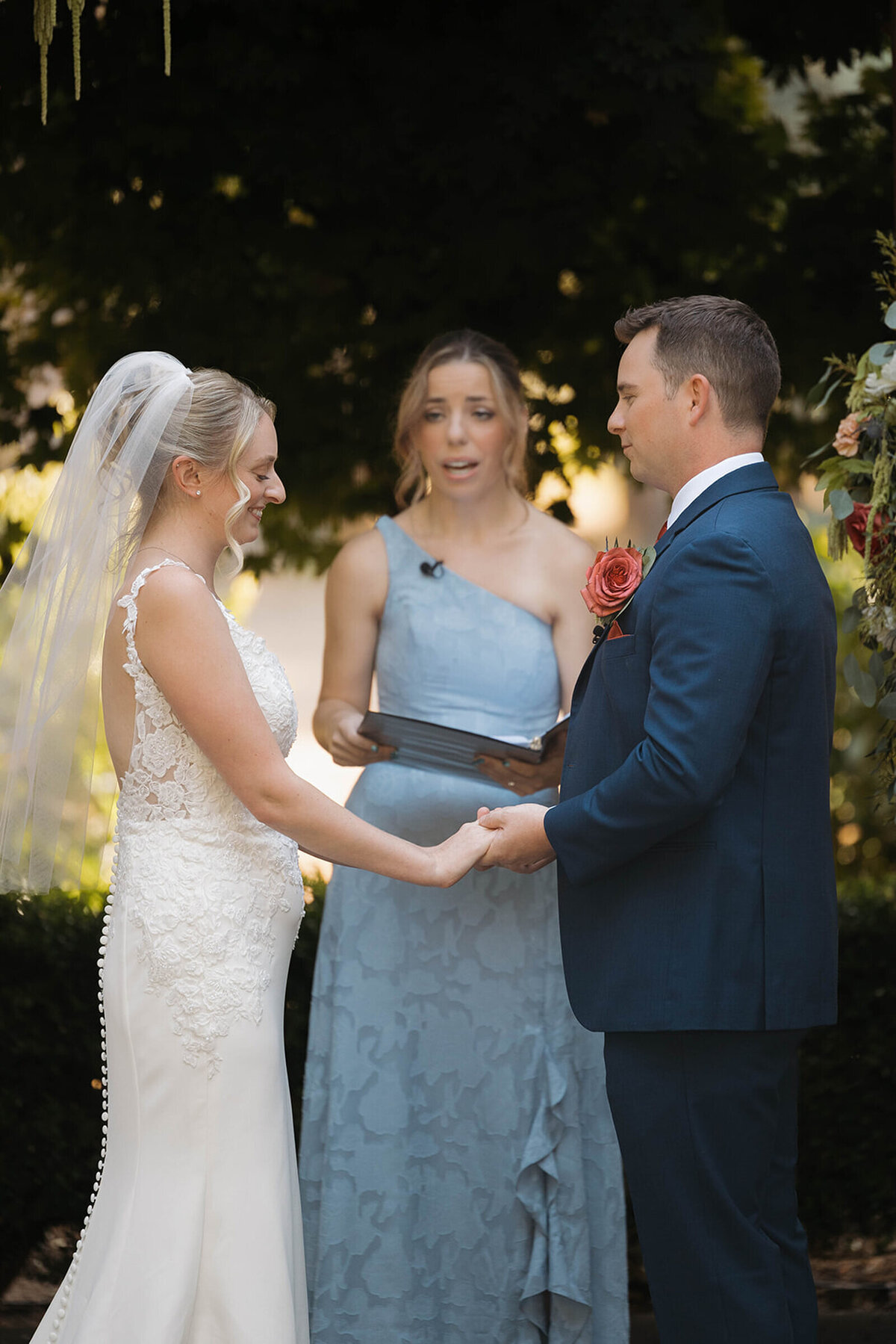Bride and groom holding hands during their vows