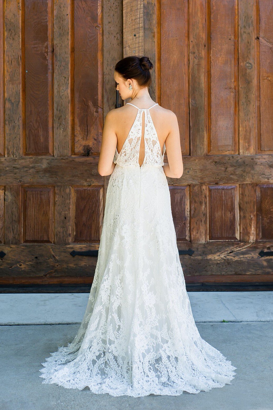 The Sabine wedding dress style features a sheer lace racerback bodice paired with a fitted crepe and lace skirt.