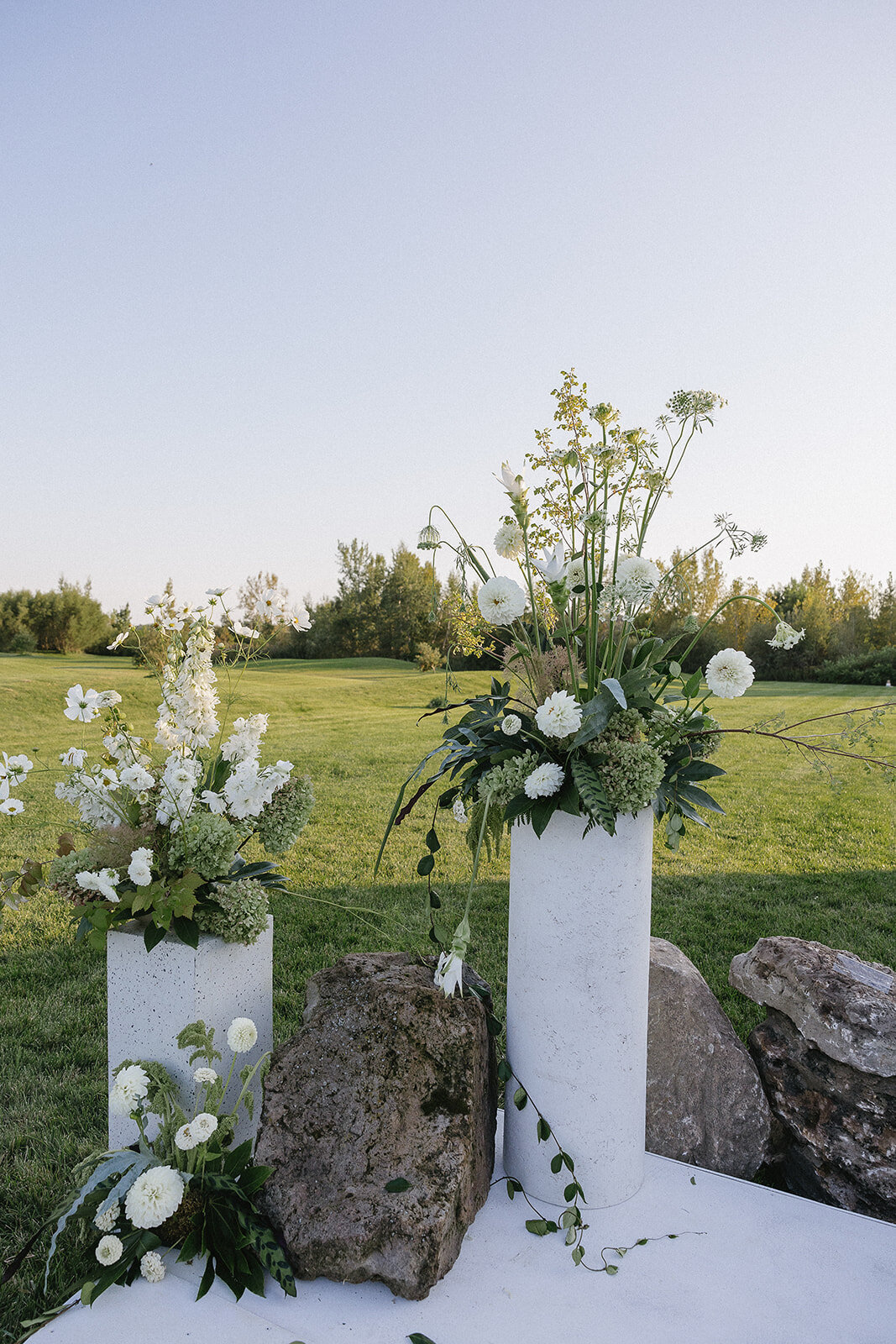 Organic, white and green floral arrangements for an outdoor wedding ceremony in Montreal.