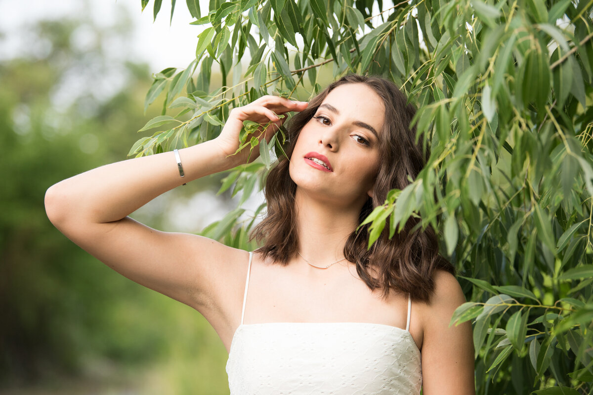 girl in white dress with willow branches in nature