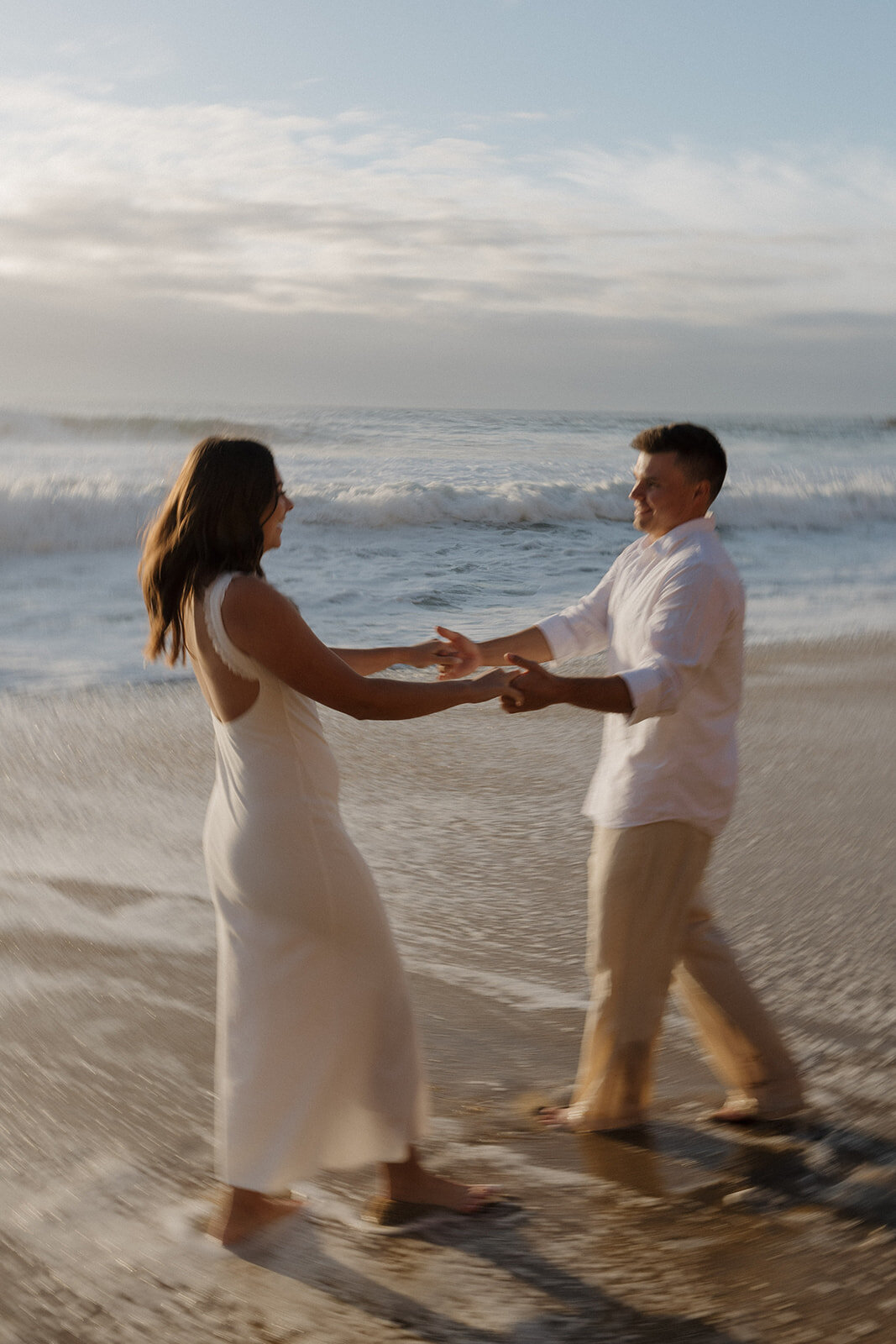 Cinematic engagement photo of a couple embracing at Panther Beach in Santa Cruz, captured by a destination wedding photographer.