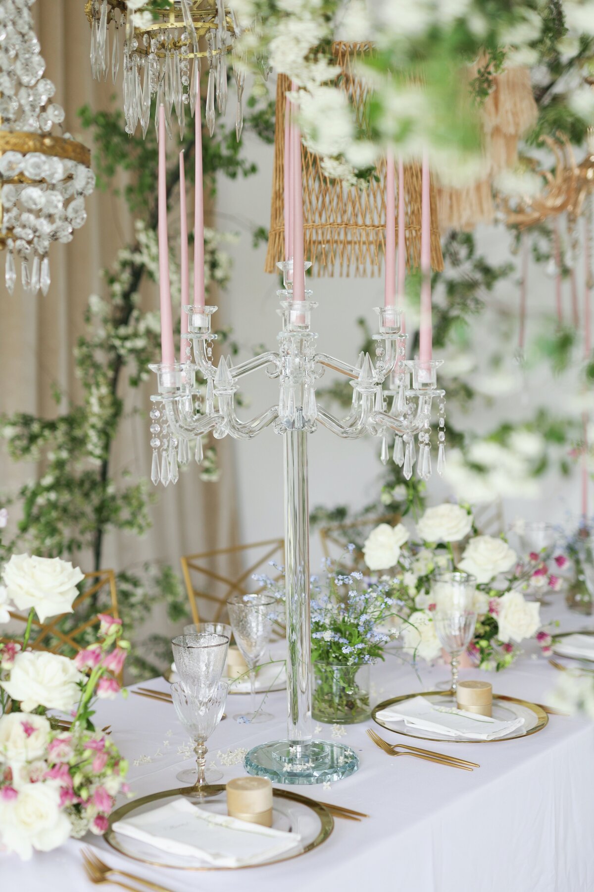 A romantic table setting with candles and flowers.