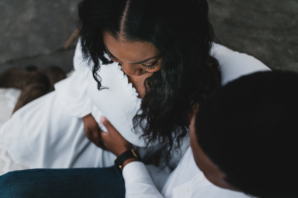 Pregnant woman sits next to a man on a bench.