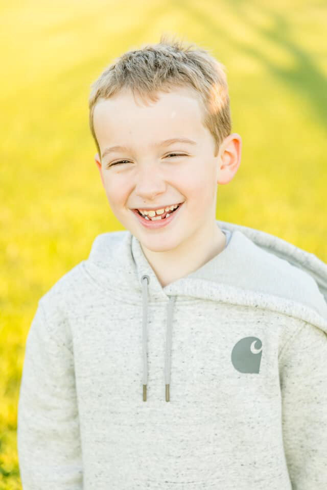 Little boy looking at the camera smiling during golden hour
