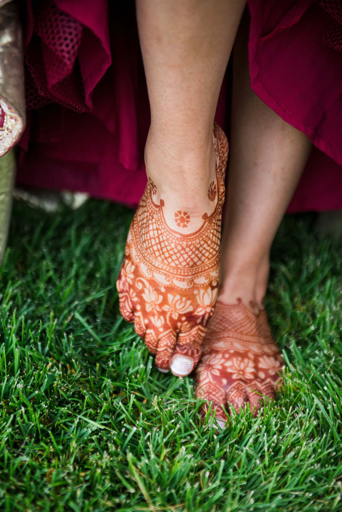 A close up shot of an Indian bride's feet covered in henna tattoo.