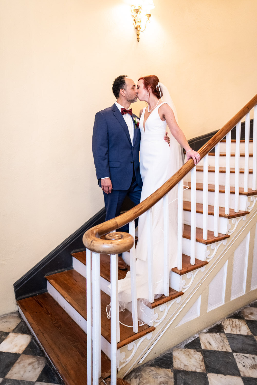 Bride and groom kiss on stairs at Latrobe's