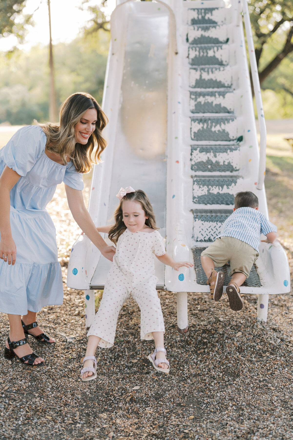 Mom and kids playing at park on a slide by Colorado Springs Family Photographer | Lauren Bounds